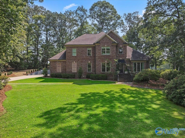 back of property featuring brick siding and a yard