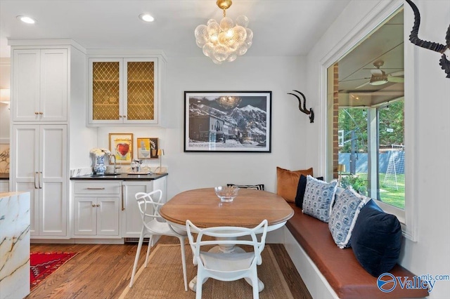 dining area featuring ceiling fan with notable chandelier, recessed lighting, and wood finished floors