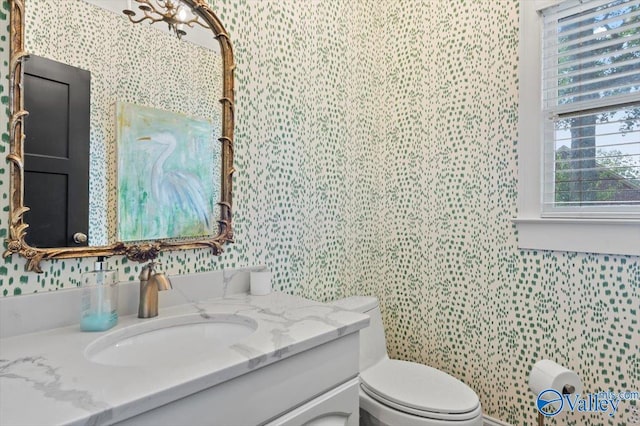 bathroom with toilet, tile walls, and vanity