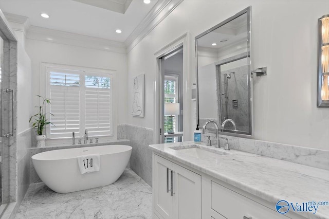 bathroom featuring vanity, wainscoting, a soaking tub, a shower stall, and crown molding