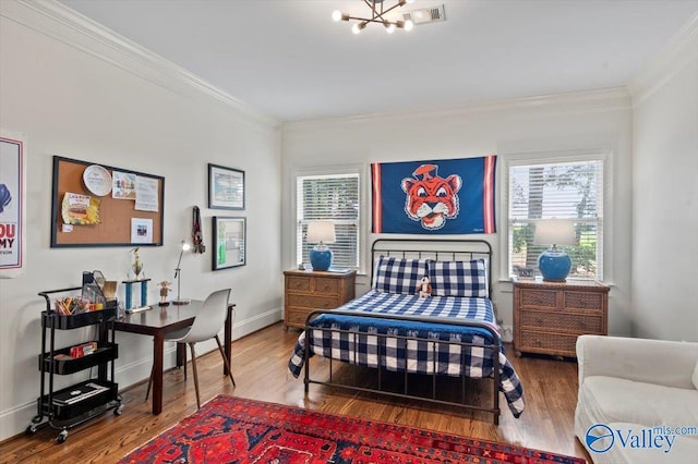 bedroom with baseboards, crown molding, and wood finished floors