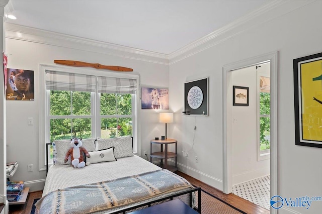 bedroom featuring ornamental molding, multiple windows, wood finished floors, and baseboards