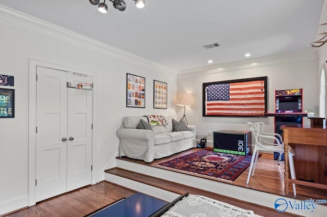 living room featuring crown molding, recessed lighting, visible vents, wood finished floors, and baseboards