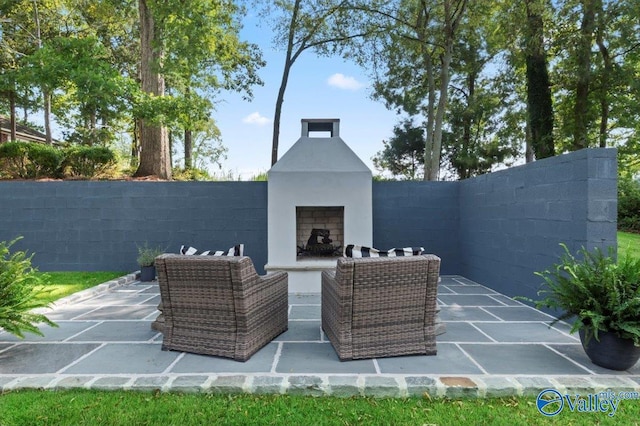 view of patio with fence and an outdoor fireplace