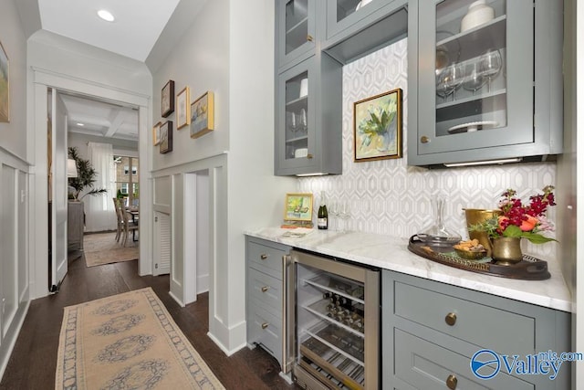 bar with gray cabinetry, decorative backsplash, light stone countertops, and beverage cooler