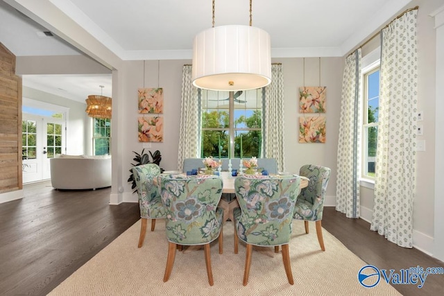 dining area featuring dark wood-type flooring, ornamental molding, and french doors