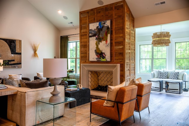 living room with hardwood / wood-style flooring, a large fireplace, and vaulted ceiling