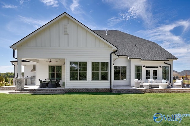 rear view of property featuring an outdoor living space, a lawn, ceiling fan, and a patio area