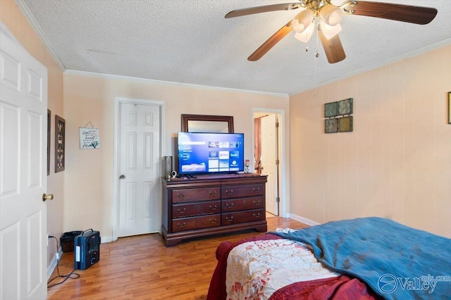 bedroom featuring light wood-type flooring, ceiling fan, ornamental molding, and a textured ceiling