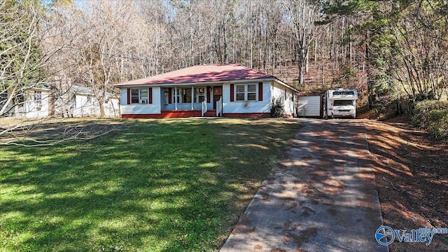 ranch-style home featuring covered porch and a front yard