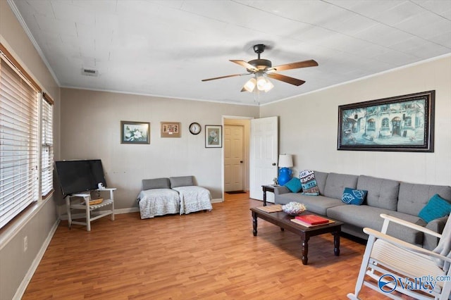 living room featuring light wood-type flooring, ceiling fan, and ornamental molding