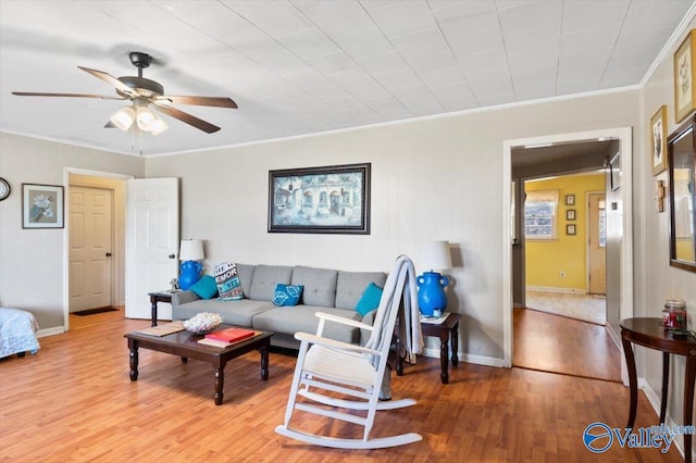 living room with hardwood / wood-style flooring, ceiling fan, and crown molding