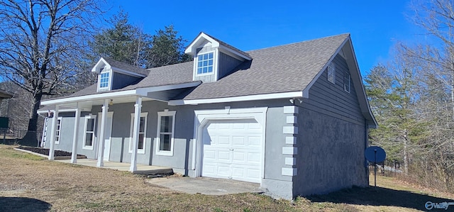 view of side of property featuring a garage, a porch, a shingled roof, and stucco siding