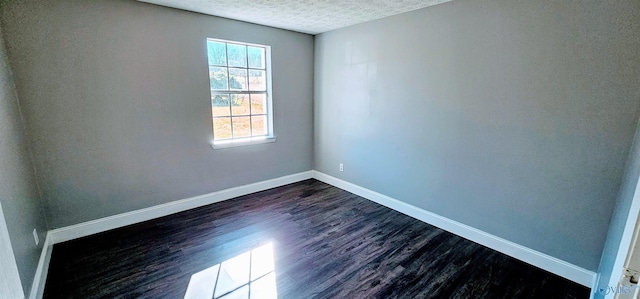 empty room with baseboards, dark wood-type flooring, and a textured ceiling