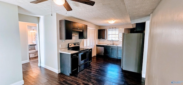 kitchen featuring a sink, light countertops, appliances with stainless steel finishes, backsplash, and dark wood-style floors