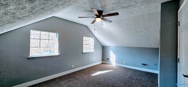 bonus room with carpet, lofted ceiling, visible vents, a textured ceiling, and baseboards