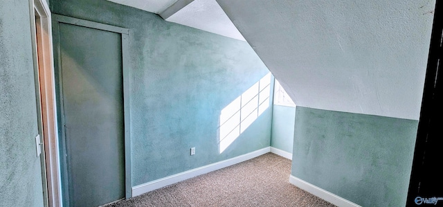 bonus room featuring lofted ceiling, baseboards, a textured ceiling, and carpet