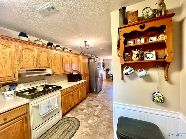 kitchen with stainless steel fridge, electric stove, and a textured ceiling