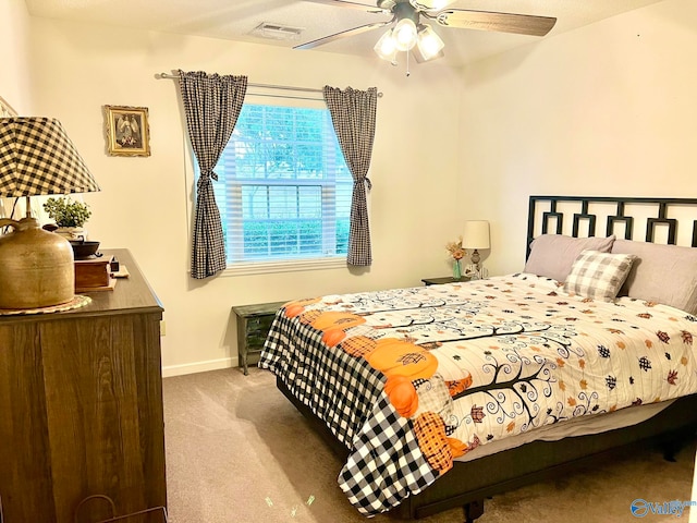 bedroom with ceiling fan, light carpet, and a textured ceiling