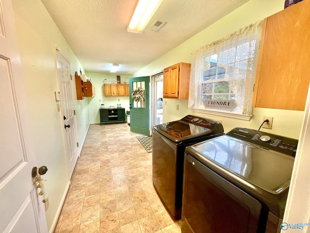 laundry room with a textured ceiling and separate washer and dryer