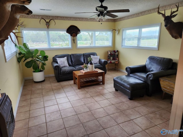 living room featuring light tile patterned floors, a textured ceiling, and a healthy amount of sunlight