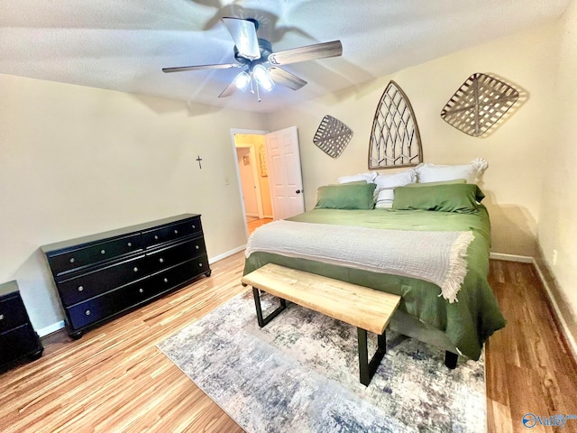 bedroom with a textured ceiling, hardwood / wood-style flooring, and ceiling fan