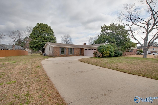 ranch-style home with brick siding, concrete driveway, a front yard, a chimney, and a garage