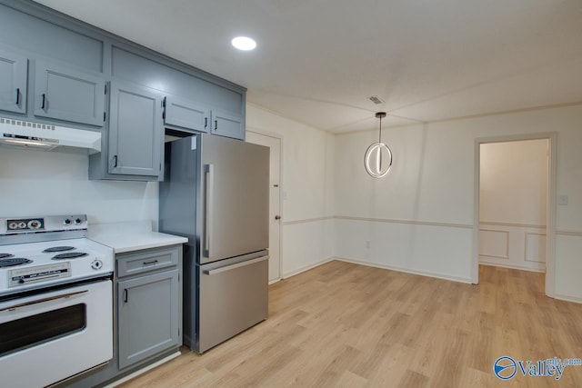 kitchen with under cabinet range hood, light countertops, freestanding refrigerator, light wood-style floors, and electric range