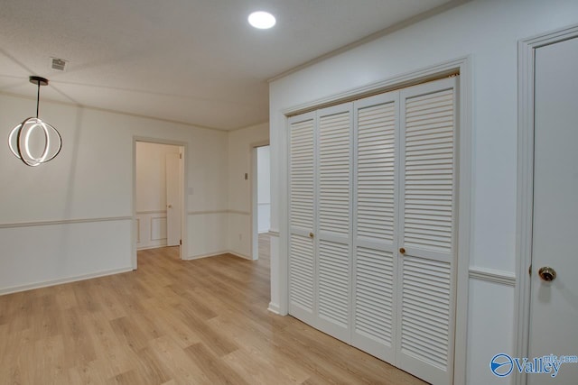 interior space featuring visible vents, baseboards, recessed lighting, light wood-style floors, and a textured ceiling