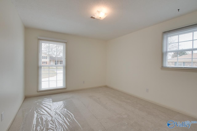 unfurnished room featuring visible vents and carpet