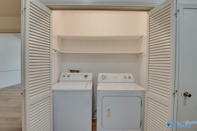 washroom featuring laundry area, washing machine and dryer, and wood finished floors