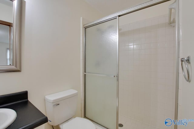 full bath featuring toilet, a stall shower, and vanity