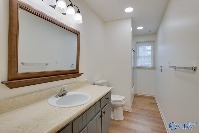 full bath with baseboards, toilet, recessed lighting, wood finished floors, and vanity