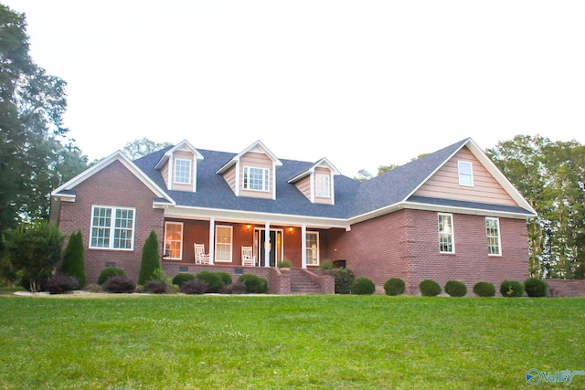 cape cod house with a front lawn and covered porch