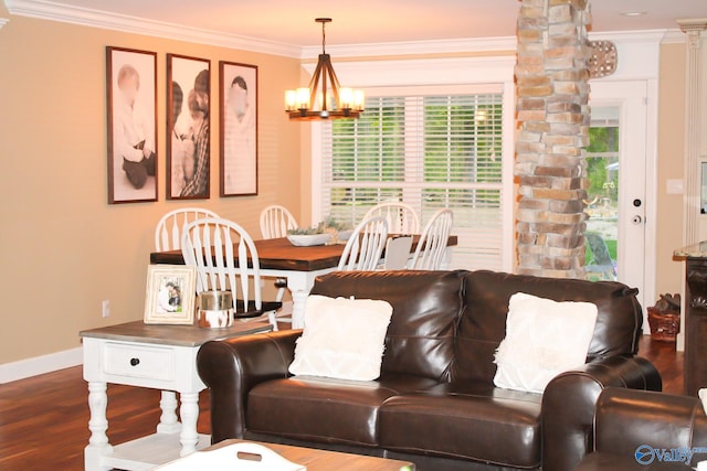 living room with a notable chandelier, wood-type flooring, crown molding, and ornate columns