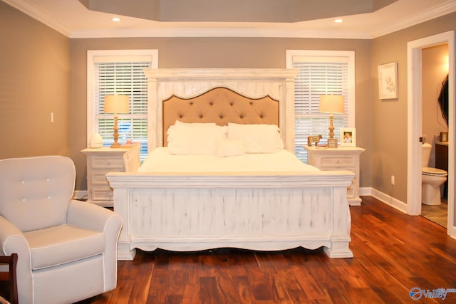 bedroom with ornamental molding, ensuite bath, and dark wood-type flooring