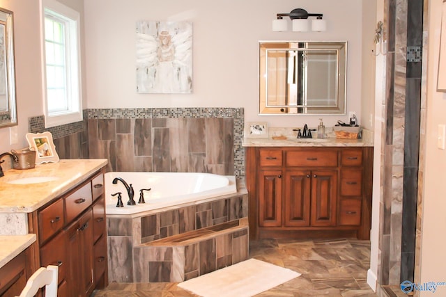 bathroom with tiled tub and vanity