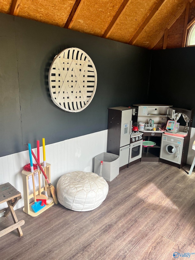 interior space with lofted ceiling, washer / clothes dryer, and hardwood / wood-style floors