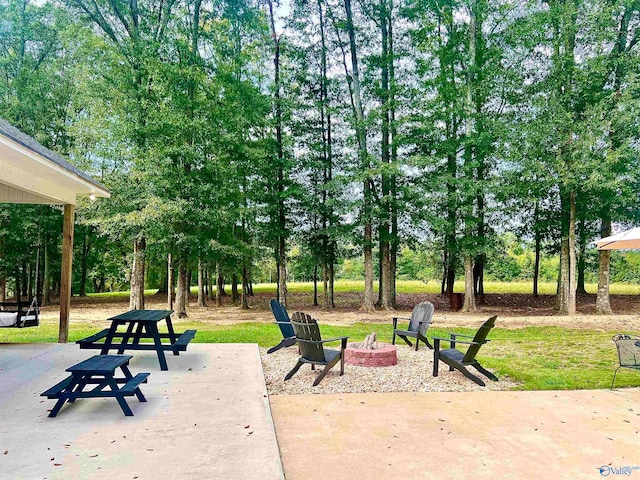 view of property's community with an outdoor fire pit and a patio area