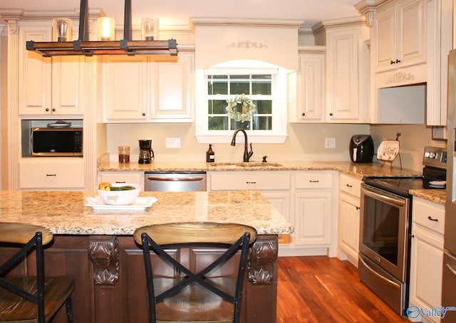 kitchen featuring dark hardwood / wood-style floors, sink, a kitchen breakfast bar, appliances with stainless steel finishes, and light stone countertops