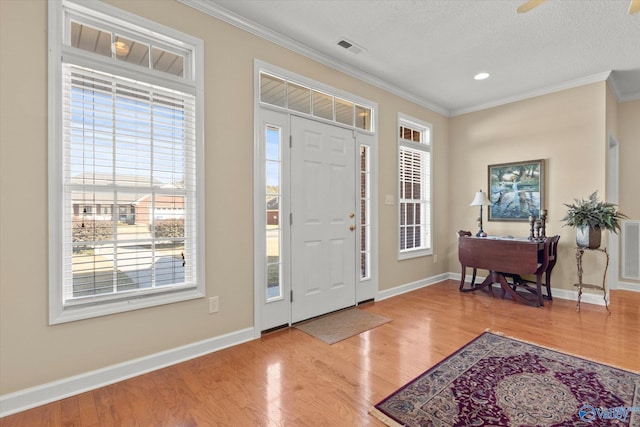 entrance foyer with ornamental molding and light wood-type flooring