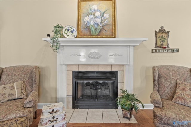 sitting room featuring a tile fireplace and light wood-type flooring