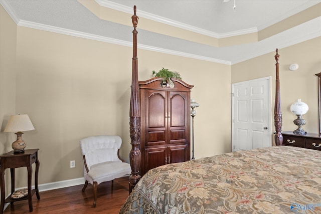 bedroom with crown molding, a tray ceiling, and dark hardwood / wood-style flooring