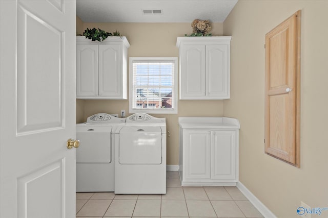 laundry room with cabinets, independent washer and dryer, and light tile patterned floors