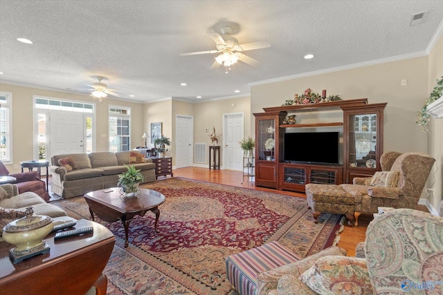 living room featuring crown molding, wood-type flooring, and a textured ceiling