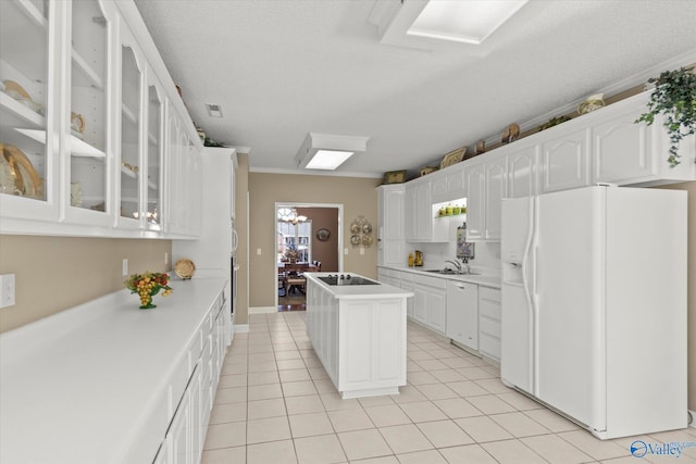 kitchen featuring sink, white cabinets, ornamental molding, white appliances, and a textured ceiling