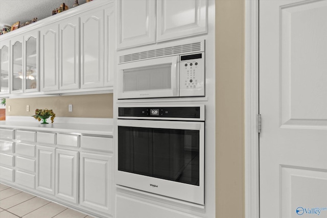 kitchen featuring white cabinetry and white appliances