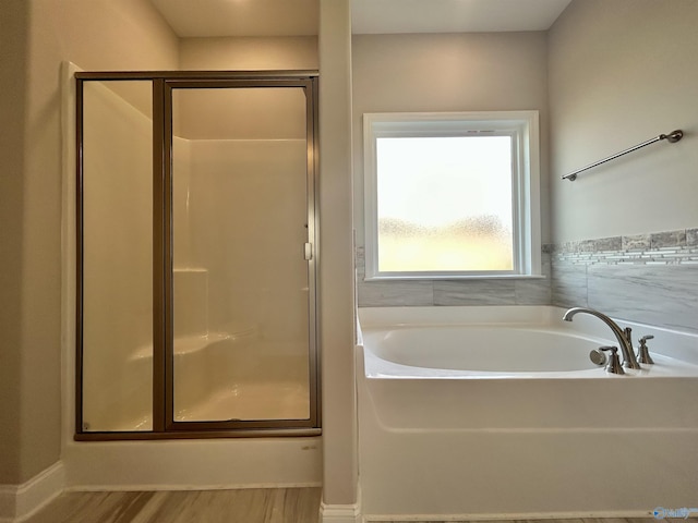 bathroom featuring hardwood / wood-style floors and separate shower and tub