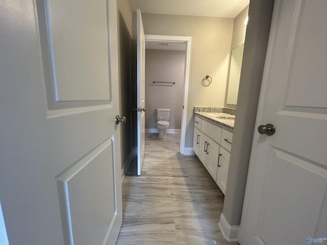 bathroom with hardwood / wood-style floors, vanity, and toilet