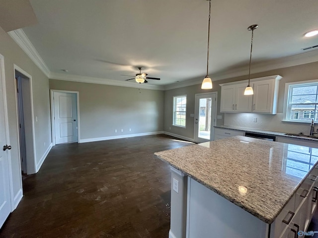 kitchen with a healthy amount of sunlight, light stone counters, dark hardwood / wood-style flooring, decorative light fixtures, and white cabinets